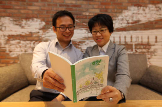 삼성화재가 고객 감동 사례집 '연'을 제작했다고 11일 밝혔다. 삼성화재 설계사(오른쪽)가 고객과 함께 사례집을 읽고 있다.